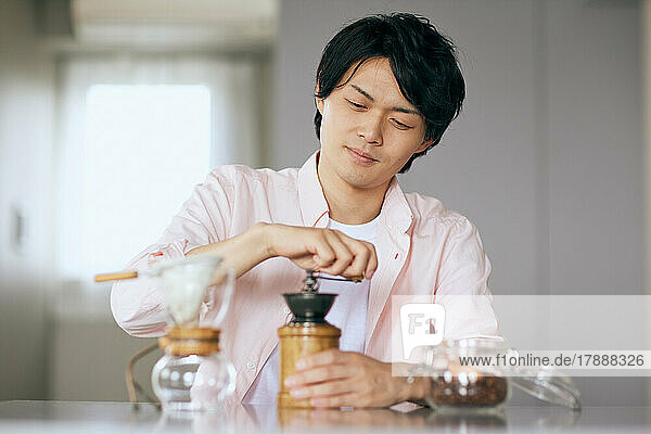 Japanese man grinding coffee at home