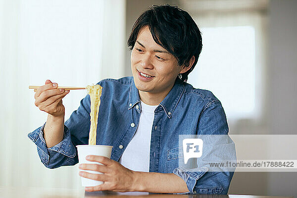 Japanischer Mann beim Essen zu Hause