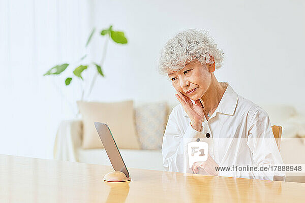 Japanische Seniorin bei der Hautpflege zu Hause
