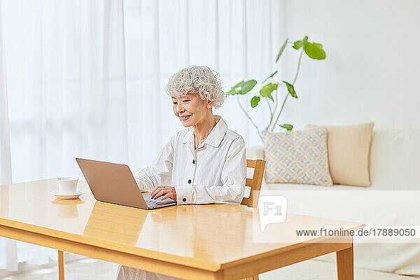 Japanese senior woman using laptop at home