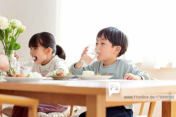Japanische Kinder essen gemeinsam zu Hause