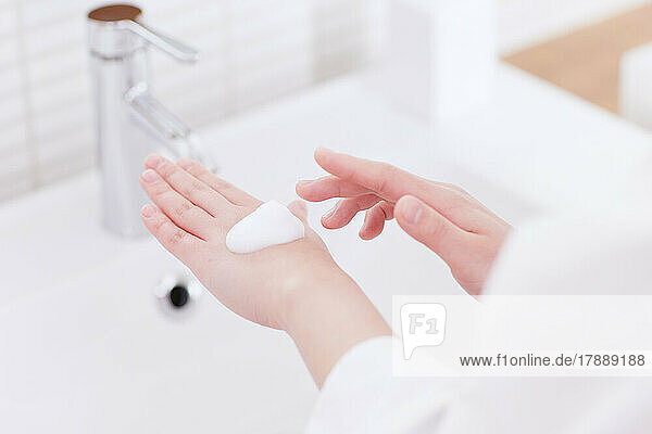 Japanerin beim Händewaschen mit schäumender Handseife