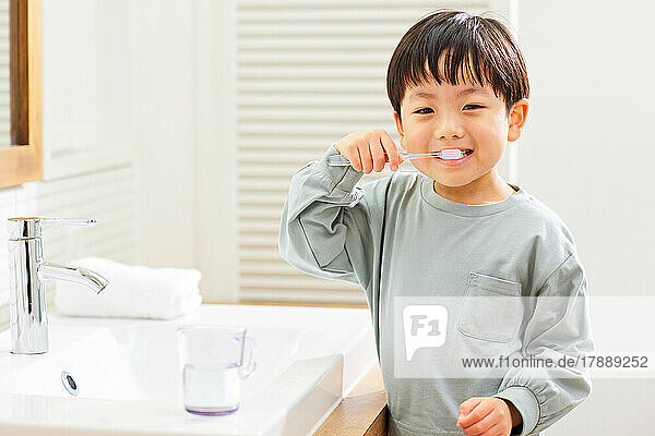 Japanese kid brushing teeth at home