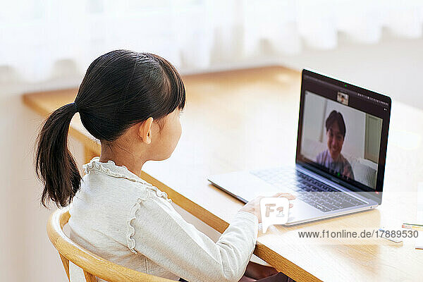 Japanisches Kind führt Videogespräch mit Laptop