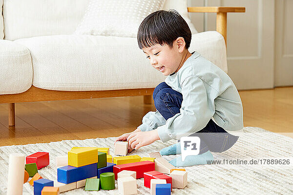 Japanisches Kind spielt zu Hause mit Spielzeug