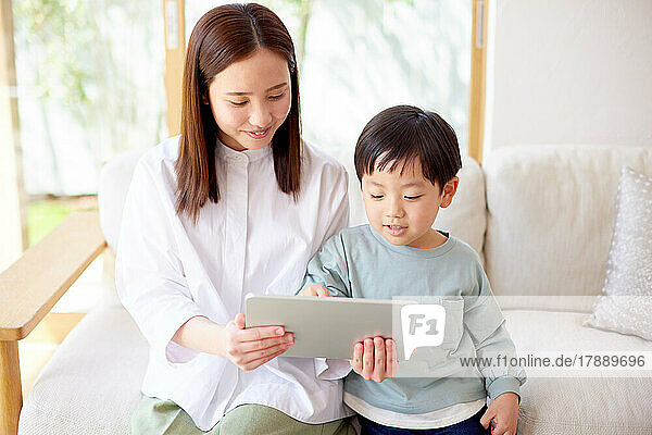 Japanese kid and mother using tablet at home