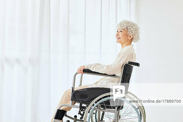 Japanische Seniorin in einem Rollstuhl