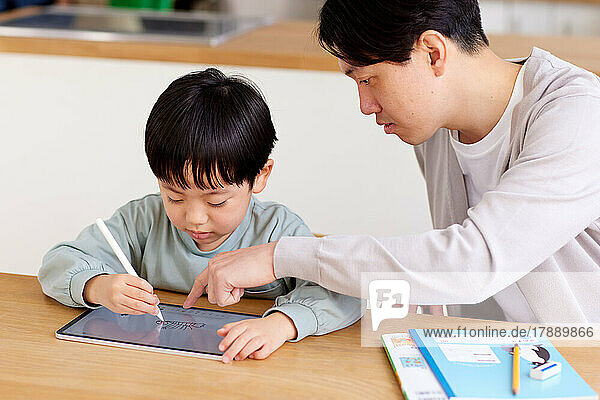 Japanisches Kind und Vater lernen zu Hause