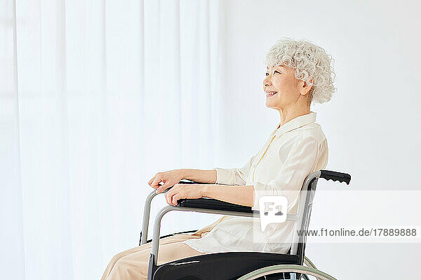 Japanische Seniorin in einem Rollstuhl