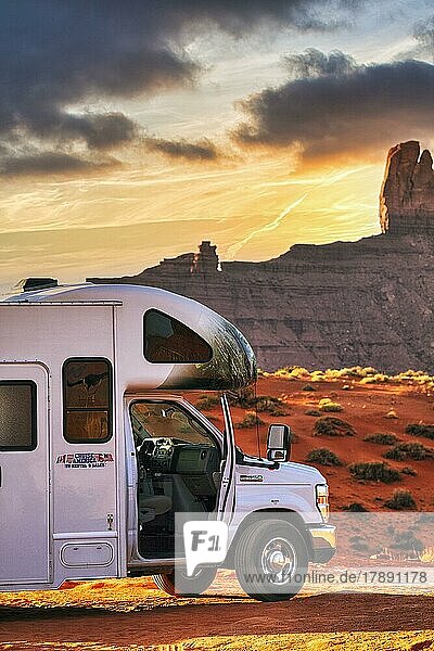 Motorhome with company logo parked on gravel road in front of striking rock formation  rock needle  panoramic road in Monument Valley  sunset  Arizona  USA  North America