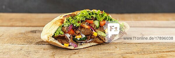 Döner Kebab Doner Kebap Fastfood Essen im Fladenbrot auf Holzbrett Panorama Textfreiraum Copyspace in Stuttgart  Deutschland  Europa