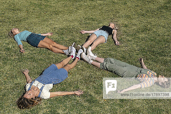 Friends lying together on grass at park