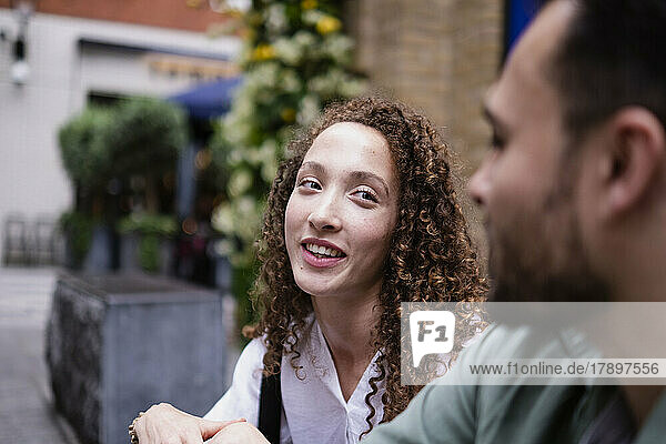 Smiling young woman talking with boyfriend