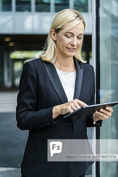 Mature blond businesswoman using tablet PC