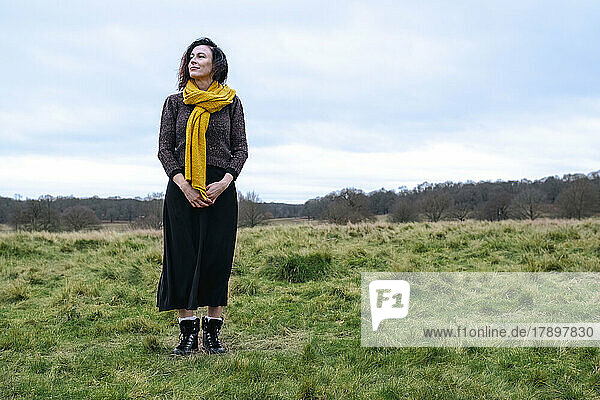 Woman wearing yellow scarf standing in field
