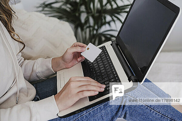 Frau nutzt Kreditkarte zur Zahlung per Laptop