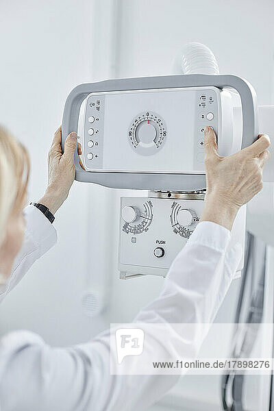 Doctor controlling X-ray machine in clinic