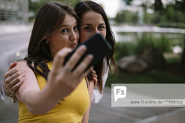 Women taking selfie using mobile phone in park