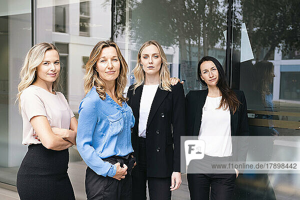 Business people standing together in front of glass wall