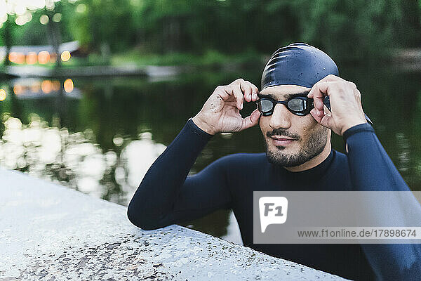 Man wearing swimming goggles in lake