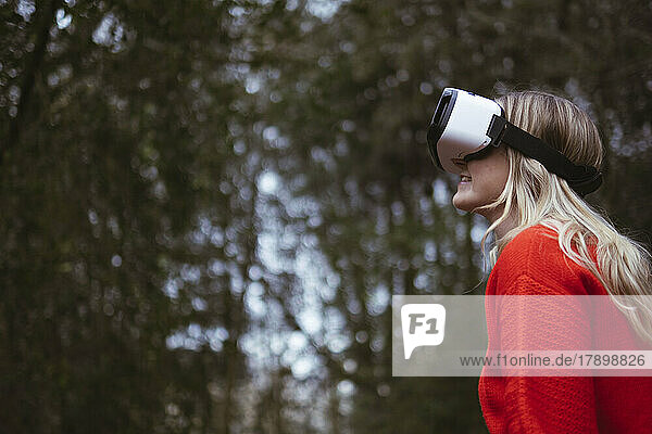 Woman wearing VR glasses in forest