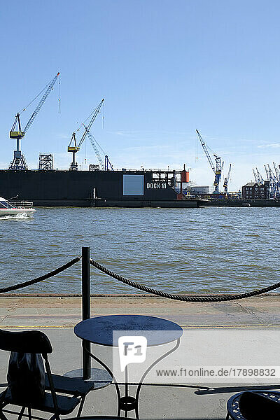 Germany  Hamburg  Outdoor table with cranes of Port of Hamburg in background