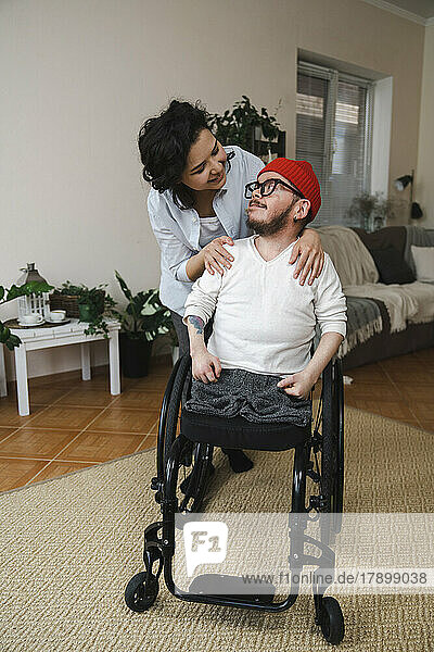 Smiling woman looking at boyfriend in wheelchair