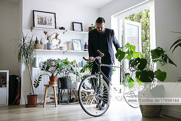 Businessman entering with bicycle at home