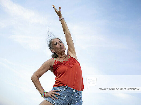 Senior woman doing gymnastics under clear sky