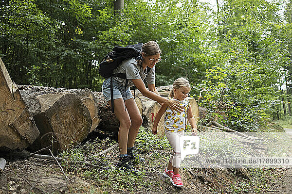 Smiling woman with daughter in forest