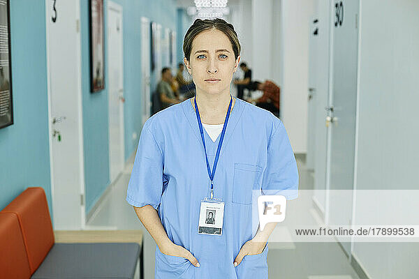 Nurse wearing scrubs standing in hospital corridor