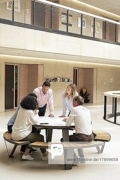 Business colleagues planning strategy in meeting at office lobby