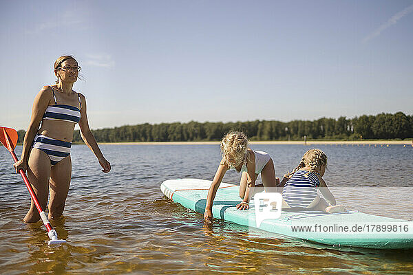Mother with daughter having fun on paddle board
