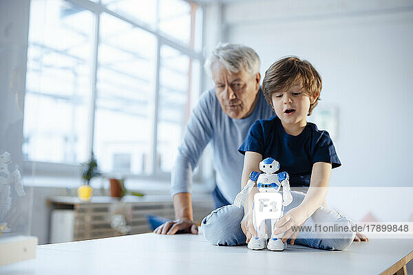Junge mit Robotermodell von Großvater zu Hause