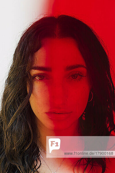 Das Gesicht einer ernsten Frau unter Rotlichteffekt