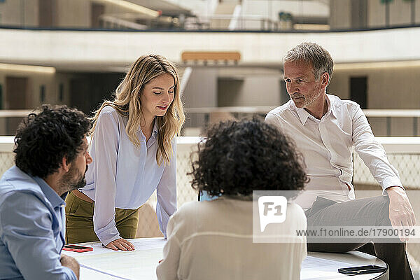 Multiracial business colleagues discussing strategy over document in meeting