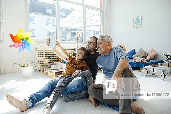 Happy family taking selfie through tablet PC in living room
