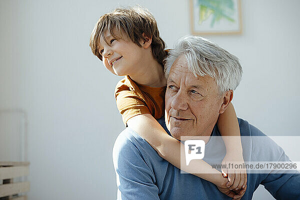 Senior man with cute grandson at home
