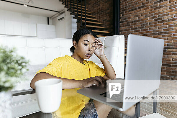 Stressed woman working on a computer in the living room