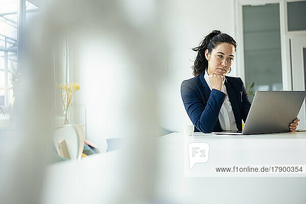 Sad businesswoman looking at laptop on table