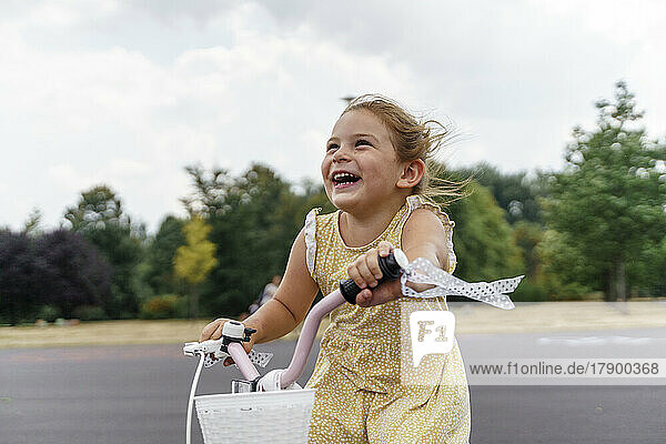 Fröhliches Mädchen genießt Radfahren im Park