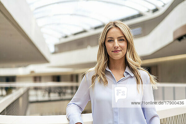 Confident businesswoman with blond hair in corridor