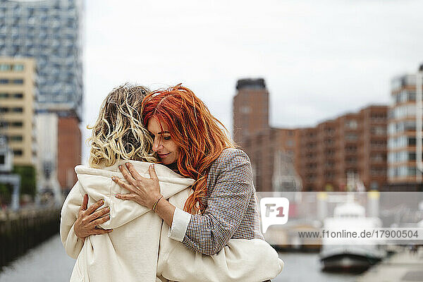 Smiling mother hugging daughter at Elbphilharmonie in Hafencity