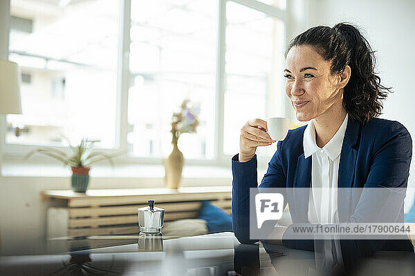 Happy businesswoman holding coffee cup