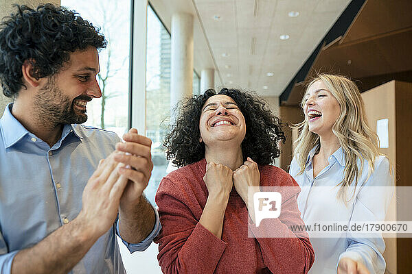 Happy woman celebrating success with colleagues in library