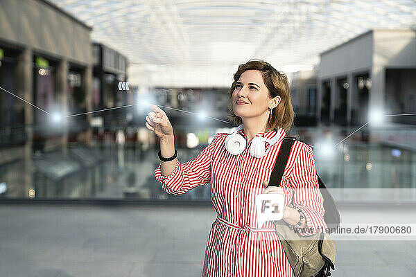 Smiling woman touching graph in shopping mall