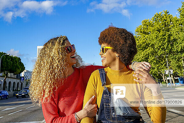 Happy lesbian couple wearing sunglasses on sunny day