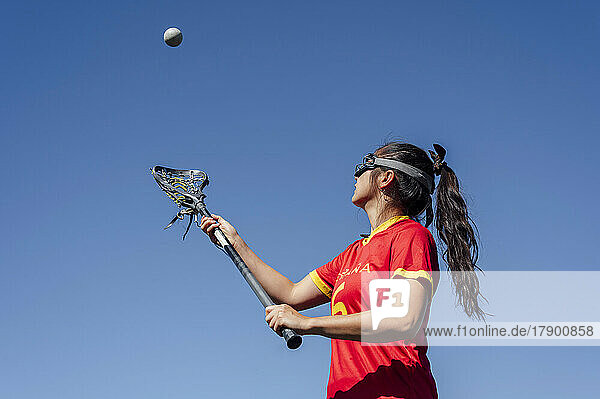 Athlete playing lacrosse under blue sky