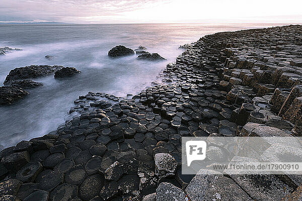 Waves rushing towards basalt stones at Giant's Causeway  Northern Ireland