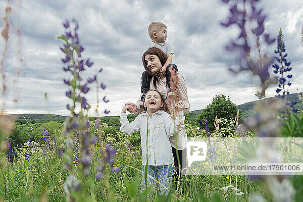 Woman with daughter and son in wildflowers meadow